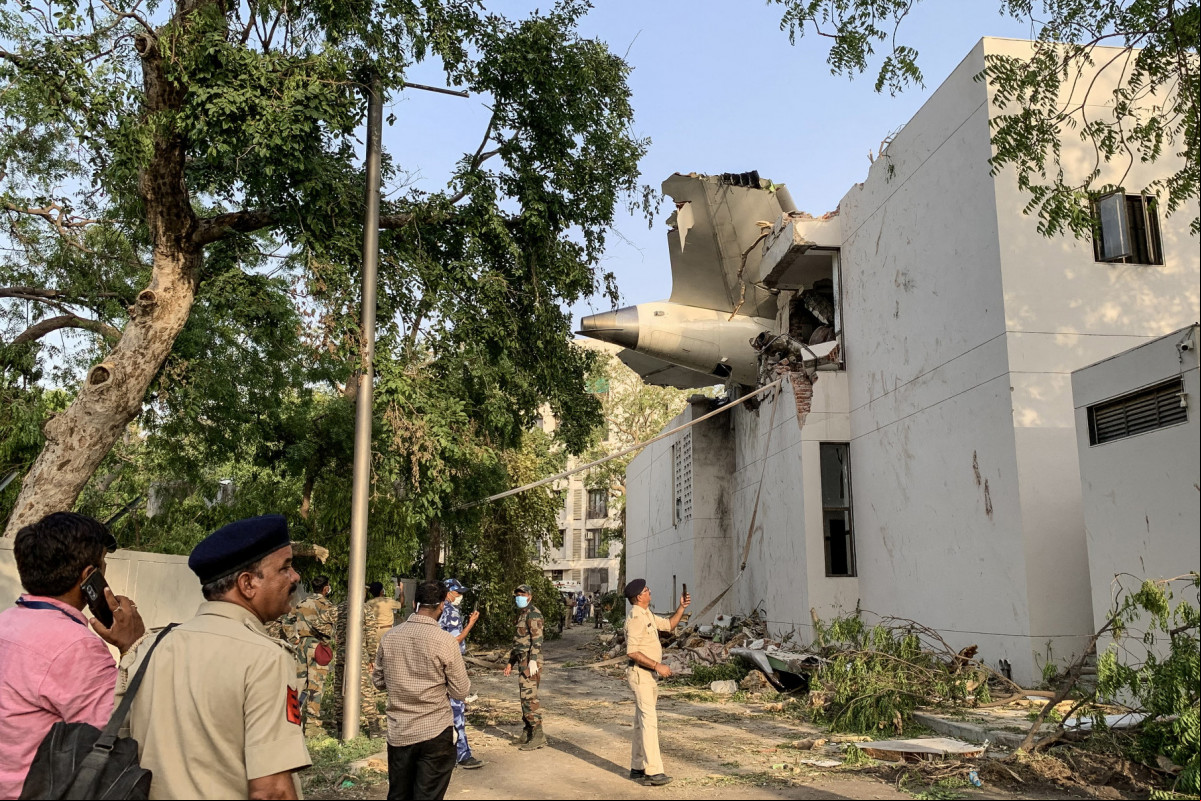 A parte traseira do voo 171 da Air India é fotografada no local após a queda em uma área residencial perto do aeroporto de Ahmedabad em 12 de junho de 2025. Um avião de ageiros com destino a Londres caiu na cidade indiana de Ahmedabad na quinta-feira e acredita-se que todas as 242 pessoas a bordo morreram, com o jato colidindo com prédios que abrigavam médicos e suas famílias. (Foto de Sam PANTHAKY / AFP)